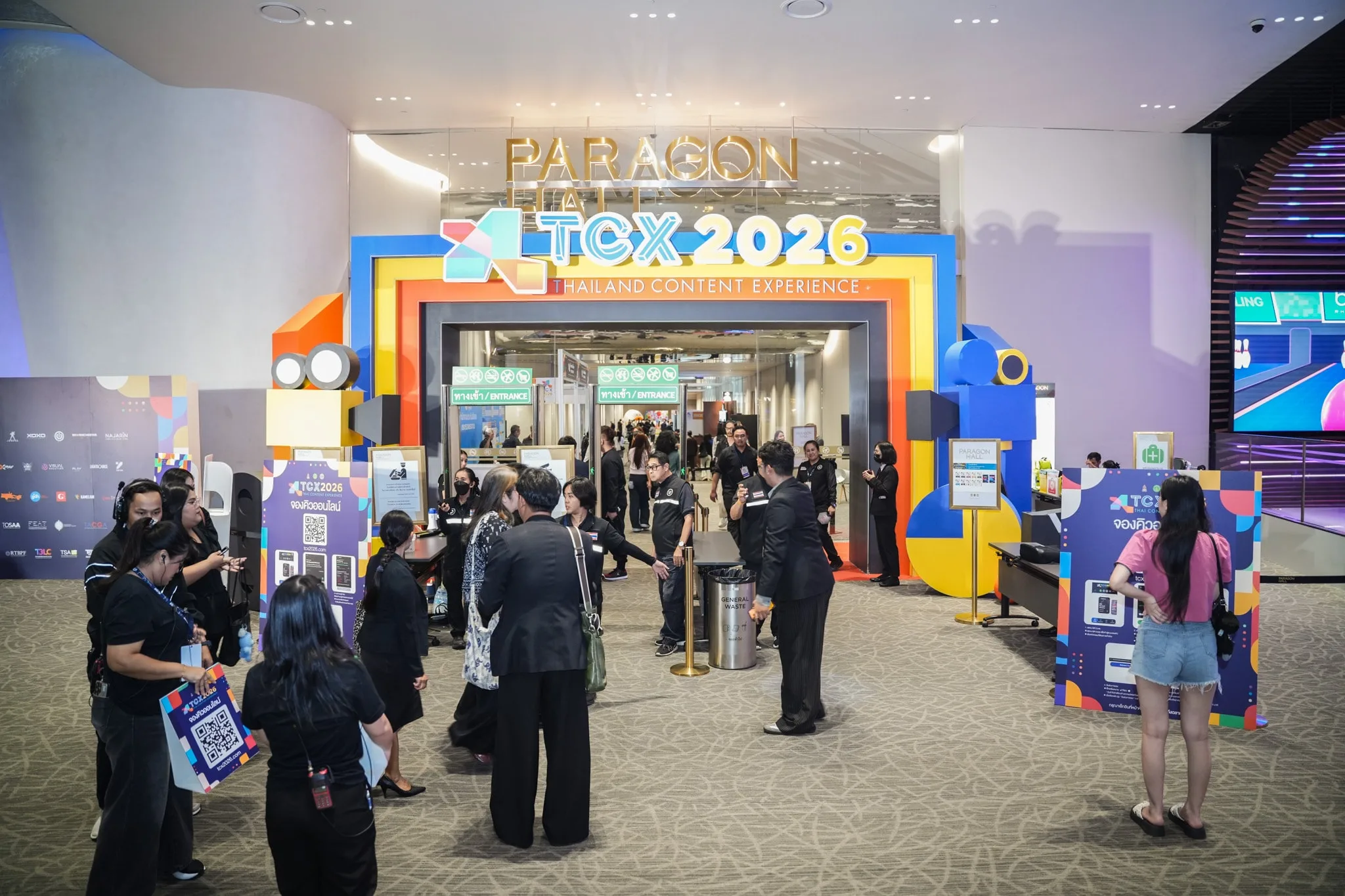 ผู้ชมเดินผ่านซุ้มทางเข้าสีสันสดใสของ TCX2026