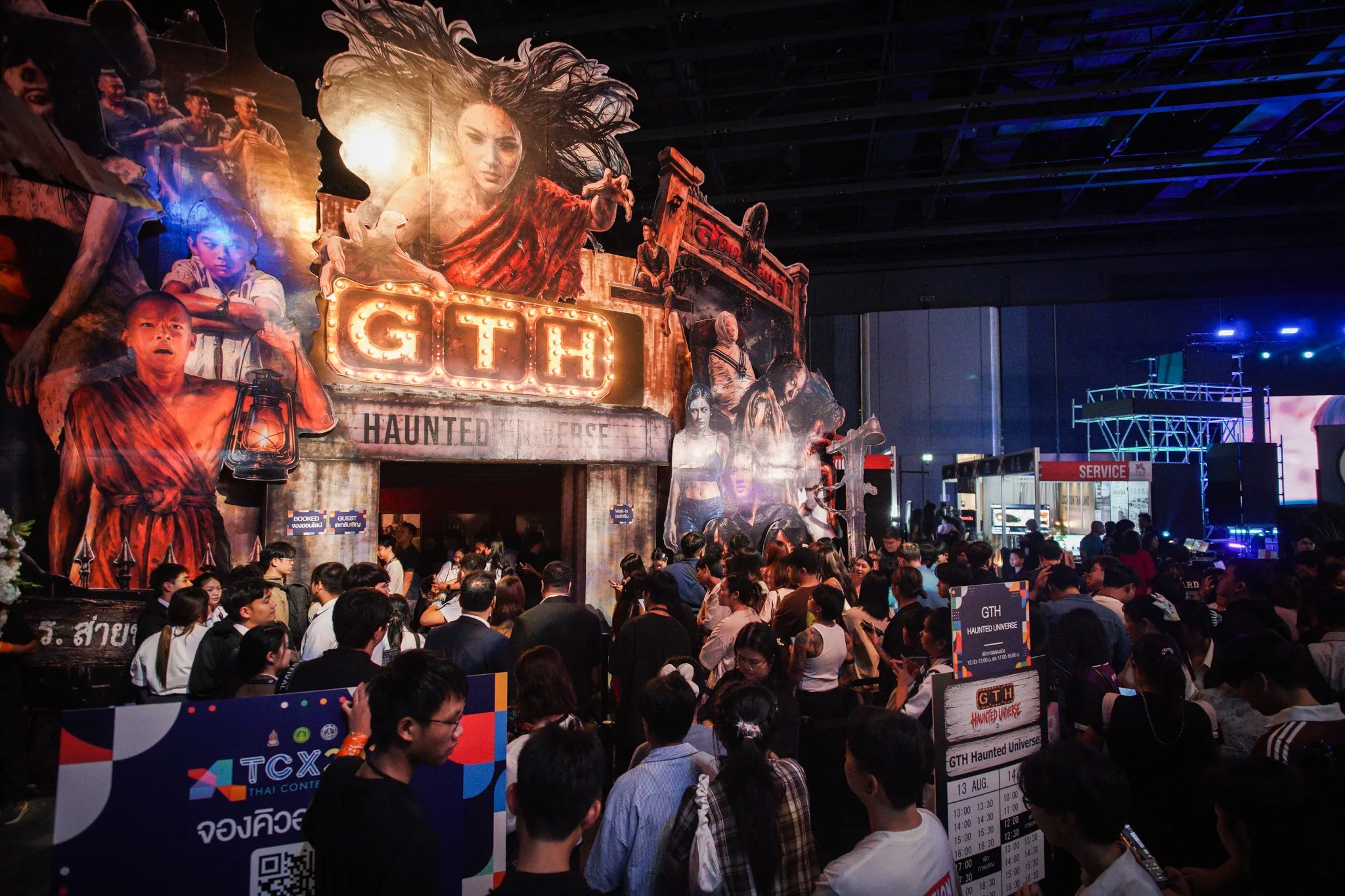 ผู้ชมบริเวณหน้าซุ้ม GTH Haunted Universe ที่สว่างด้วยแสงสี